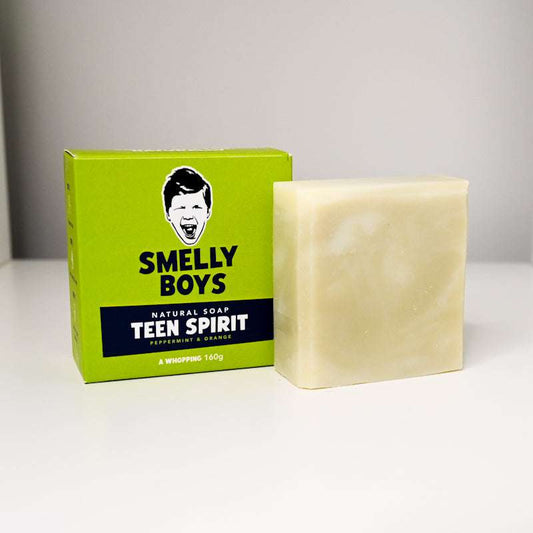 Bar of soap next to its packaging labeled 'Smelly Boys Teen Spirit' on a white background