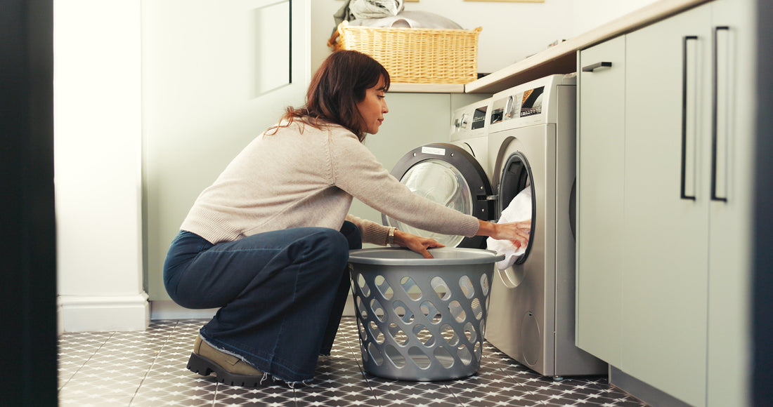 Woman unloading a washing machine into a basket