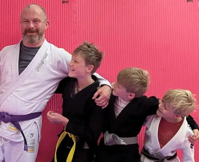 Father with three sons all wearing jiu-jitsu gis.