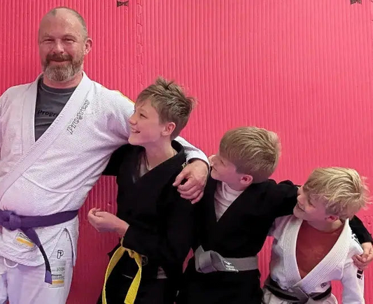 Father with three sons all wearing jiu-jitsu gis.