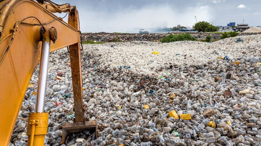 A JCB digger arm and a mountain of plastic waste