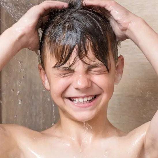 Teen boy washes hair using Teen Spirit Shampoo