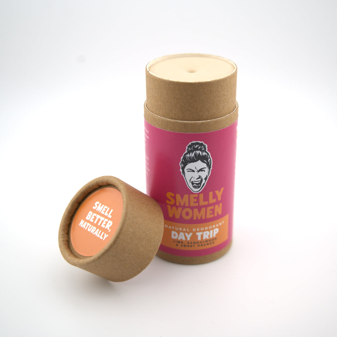 A cardboard deodorant tube with a pink label featuring a face and text on a white background