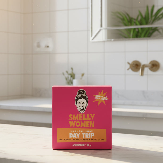 Pink soap box labelled 'Smelly Women Day Trip' in a sunny bathroom.