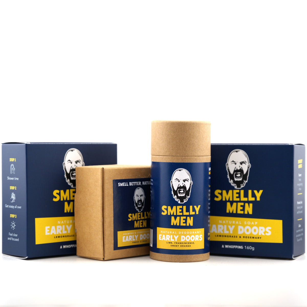 A men's personal care product set from Smelly Men on a white background, featuring a cylindrical cardboard deodorant tube with a navy blue and yellow label in the center, flanked by two matching rectangular boxes.