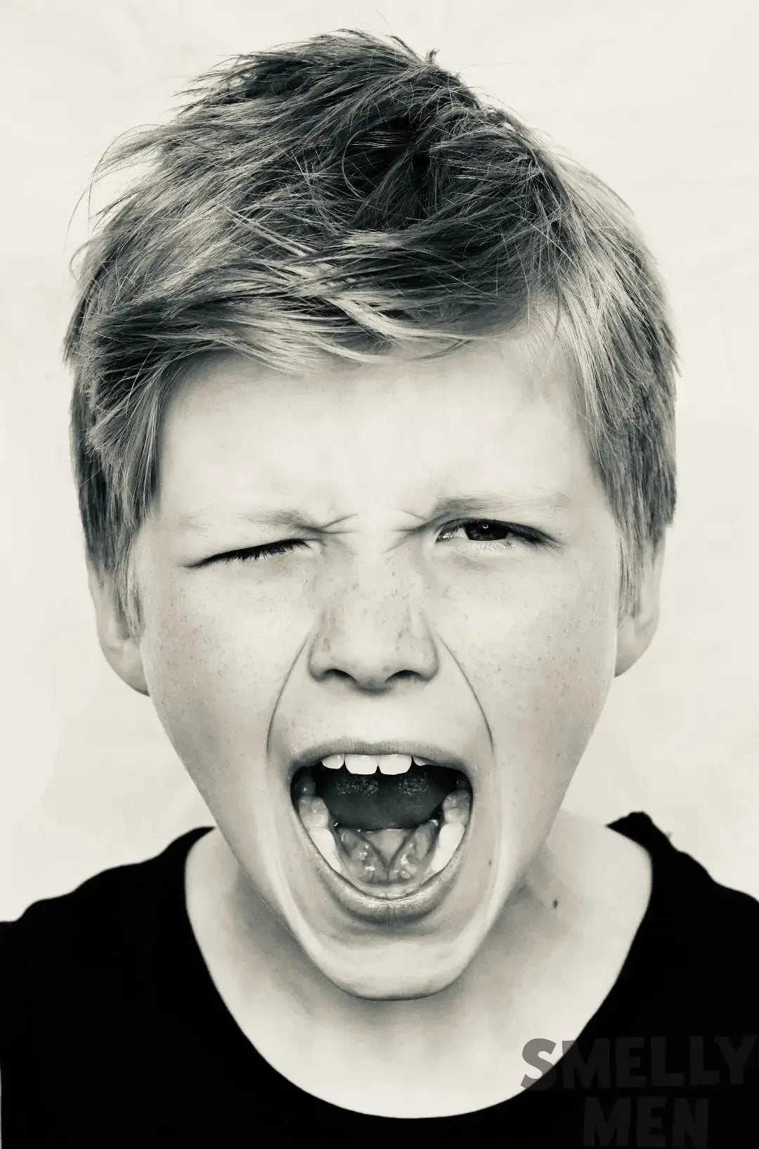 Mono image of boy shouting at camera with white background