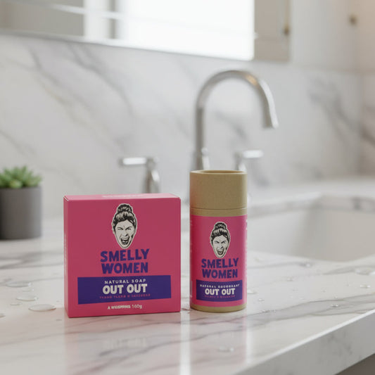 Pink 'Smelly Women' soap and deodorant with a cartoon face on a marble work top in a bathroom.