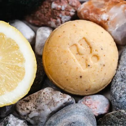 Teen Spirit shampoo with a lemon on pebbles