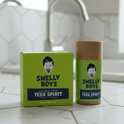 Two 'Smelly Boys' products on a bathroom counter, one green soap bar and one brown container.