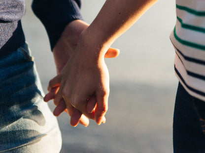 Two people holding hands with a blurred background