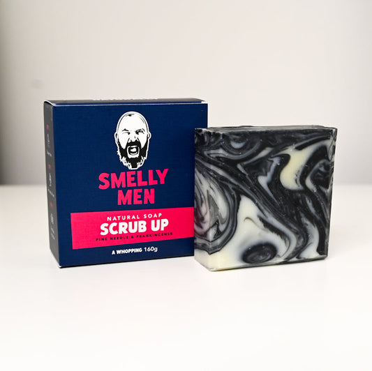Bar of soap with marbled pattern next to its packaging on a white background